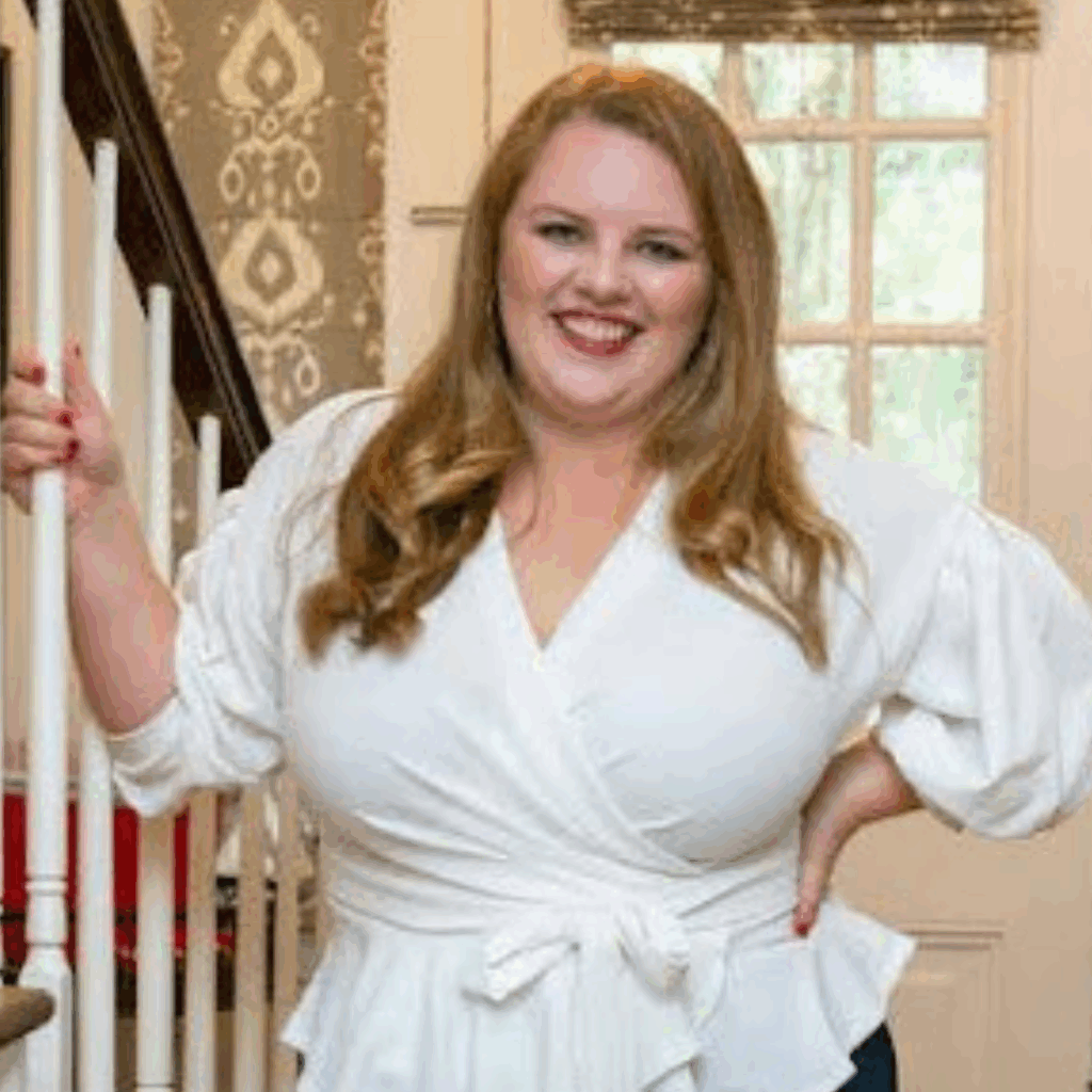 photo of Taylor Mack, a young Alumni Council member, a woman standing next to staircase smiling in white blouse
